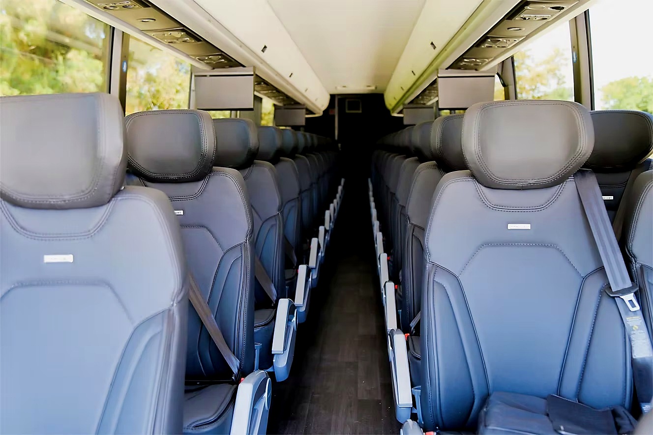 Close view of reclining coach seats with headrests and seatbelts inside a Four Season Travel coach