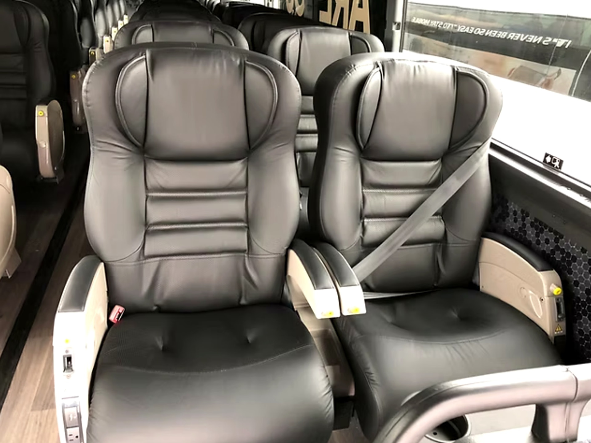 Close view of premium leather reclining seats with armrests and seatbelts in the Four Season Travel VIP coach