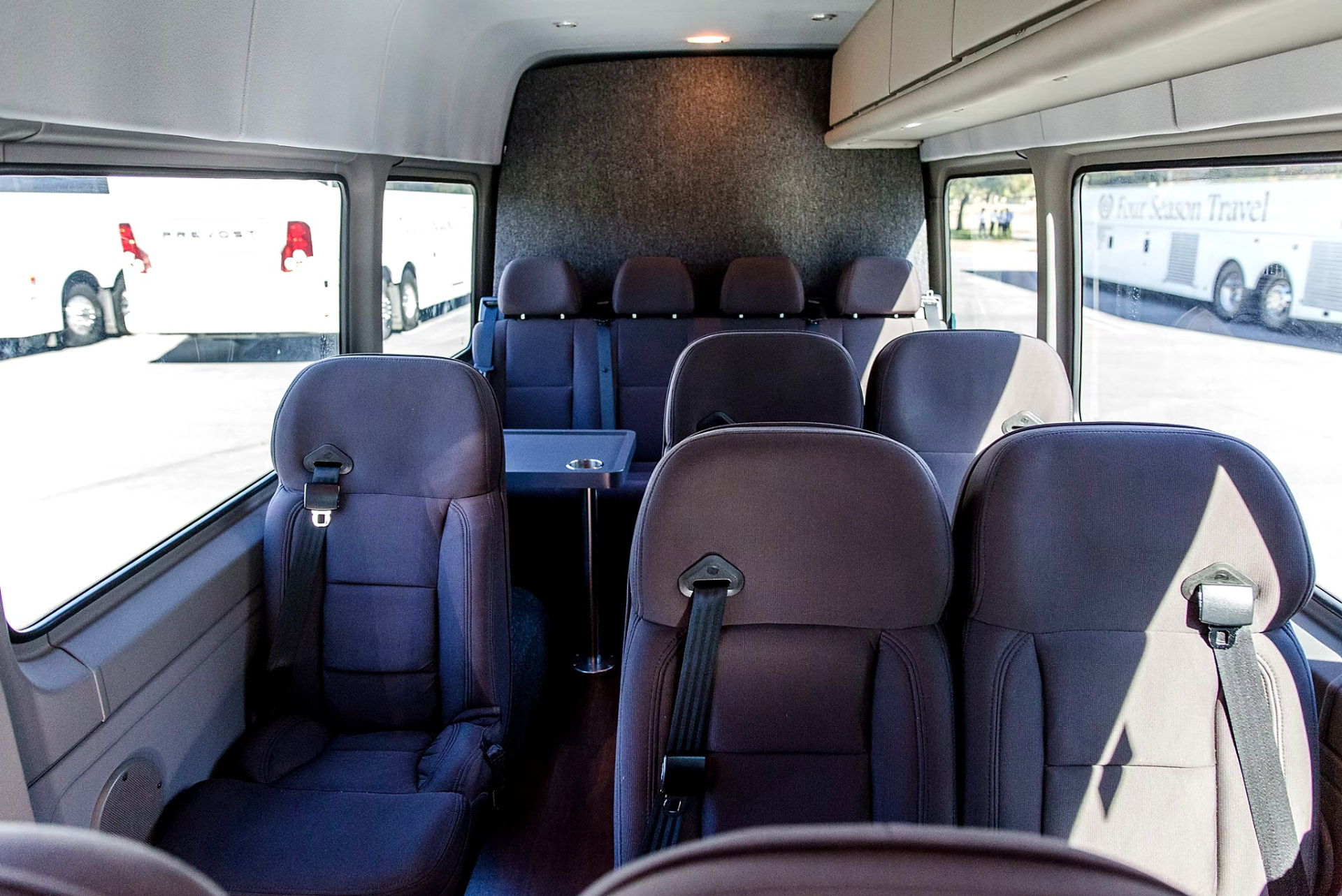 Four Season Travel Mercedes-Benz Sprinter interior looking down the cabin at passenger seats and a fold-out table